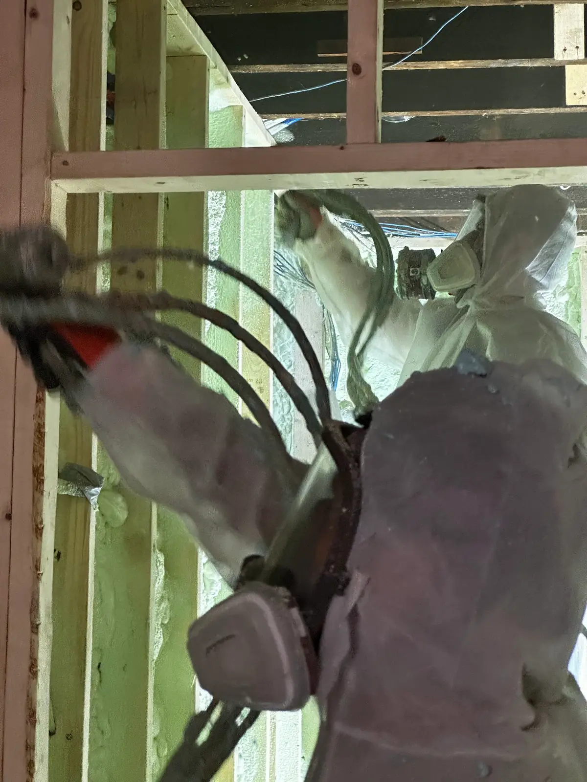 Caliber Certified installer in white protective coveralls spraying 3.5" (R22) of 2lb closed-cell spray foam across exterior 2x6 wood stud cavities in Burlington (Roseland & Aldershot) [JOB-2025-08-09-01]